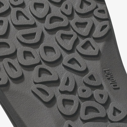 Gray rubber sole with raised canoe and rock-shaped tread pattern and brand marking.