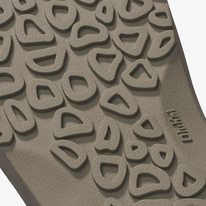 Tan clay tile with embossed repeating curved pattern and brand name visible on surface.