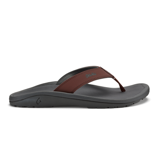 Flip-flop with gray foam sole and brown leather thong strap, side view.