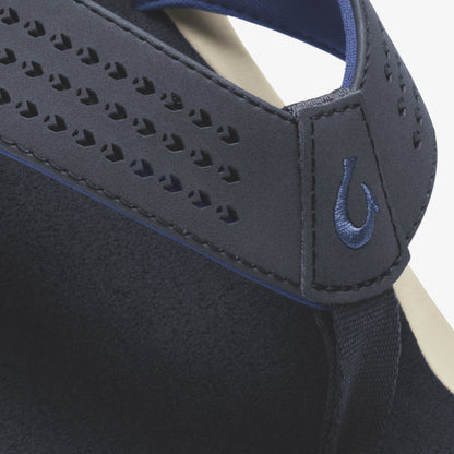 Dark blue slip-on shoe with perforated upper, blue accent trim, and embroidered logo detail on the side.