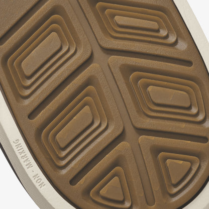 Tan and white shoe sole with geometric rectangular and triangular tread pattern.