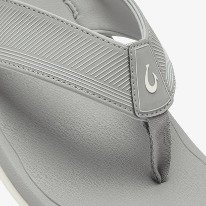 Light gray thong sandal with textured upper strap, white logo detail, and white sole.