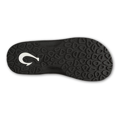 Black lava rock flip-flop sole with textured geometric pattern and white logo detail.