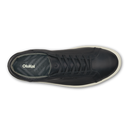 Black lace-up high-top sneaker with cream-colored sole and OluKai branding on the tongue, shown from above.
