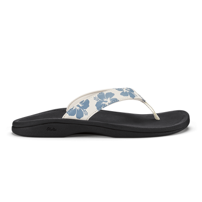 White and blue floral thong sandal with black sole and curved footbed.