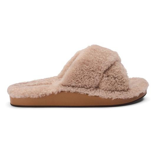 Tan fuzzy slippers with a knotted bow detail on the upper and brown sole, shown in profile view.