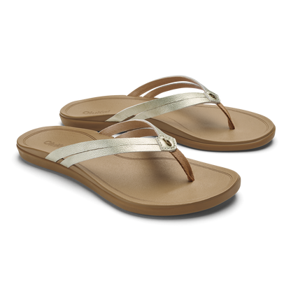 Pair of tan flip-flops with white and brown metallic straps and rounded toe posts.