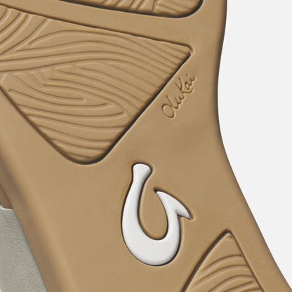 Warm sand-colored tapa with embossed leaf patterns and white fish hook accent detail.