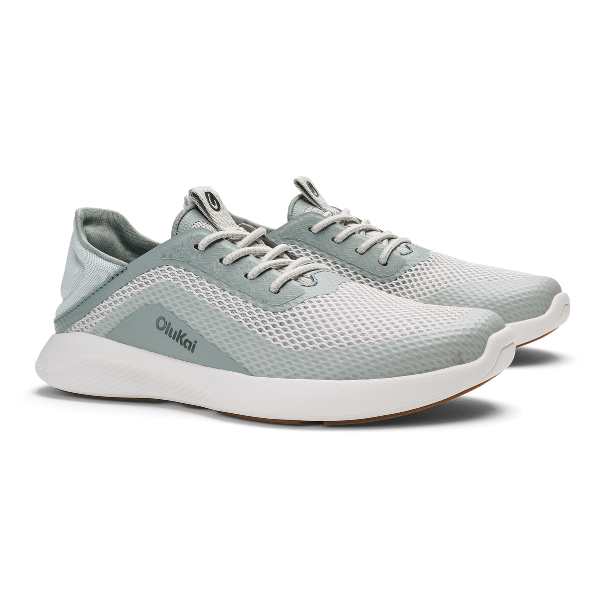 Pair of Olukai Kialoa running shoes in sterling gray and cream with mesh upper and white sole.