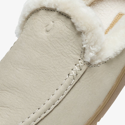 Ecru leather slip-on shoe with white fleece collar trim and cross-stitch detailing on the vamp.